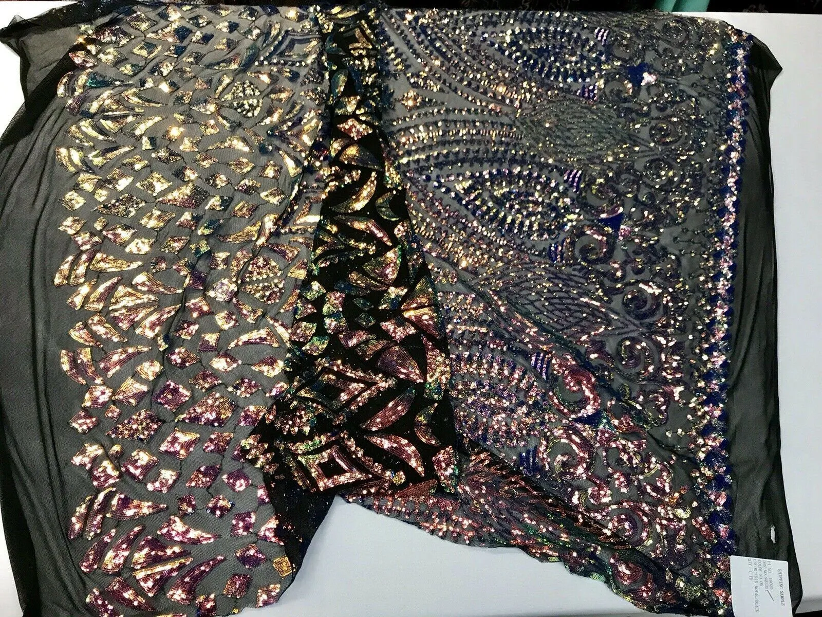 Rainbow iridescent sequin diamond design on a 4 way stretch black mesh-by the yard.